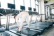 A woman is running on a treadmill in a gym.