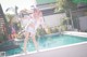 A woman in a bunny costume standing on the edge of a swimming pool.