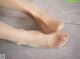 A close up of a person's feet on a tiled floor.