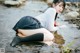 A woman in a school uniform is sitting in the water.