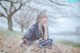 A woman sitting in a field of tall grass.