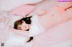 A woman laying on top of a pink rug next to pillows.